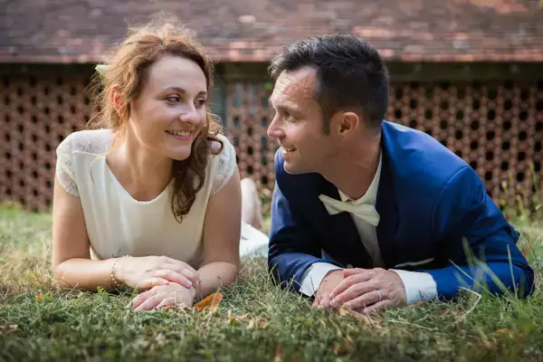 Mariés allongés dans l'herbe et se regardant