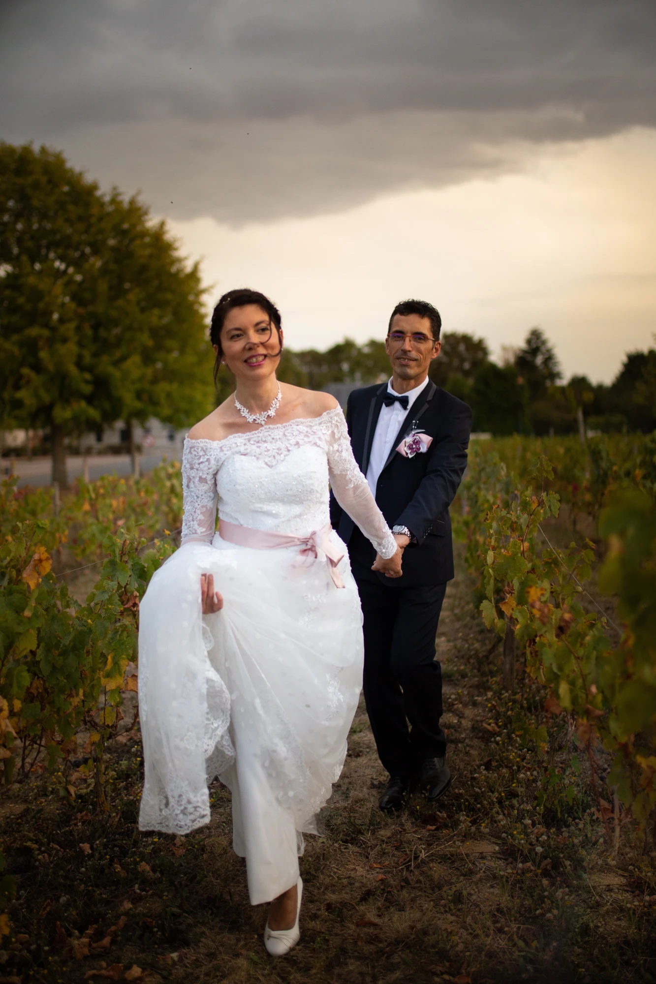 pose de mariés qui marchent dans les vignes