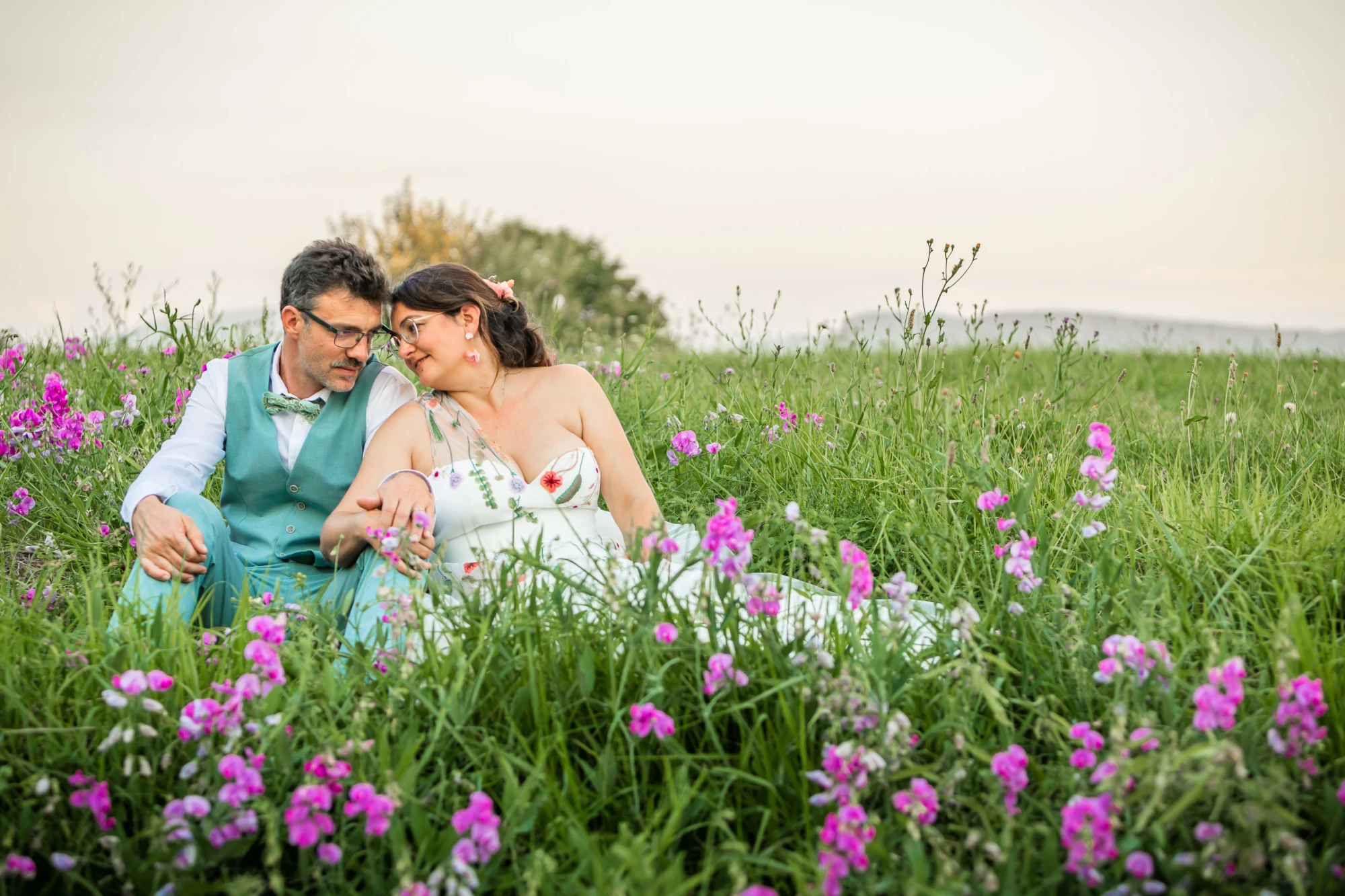pose des mariés dans un champs de fleurs dans le Jura près de Poligny